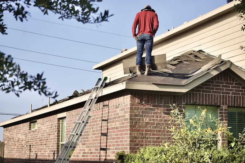 Professional roofer working on a residential roof in Fishers Bank